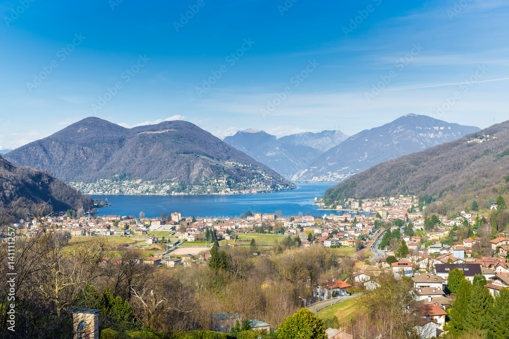 Lake Lugano, Porto Ceresio, Italy. Picturesque aerial view of Porto Ceresio and Besano. In the background Switzerland with Marcote, Melide and the Alps