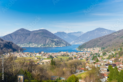 Lake Lugano, Porto Ceresio, Italy. Picturesque aerial view of Porto Ceresio and Besano. In the background Switzerland with Marcote, Melide and the Alps