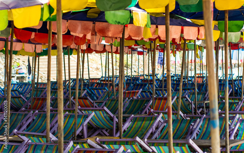 Old umbrella and chairs on beach photo