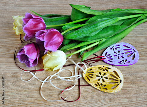 Tulips and Easter decorations on wooden background. 