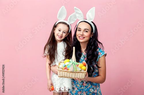easter, family, holiday and child concept - close up portrait of little girl and mother coloring eggs for easter