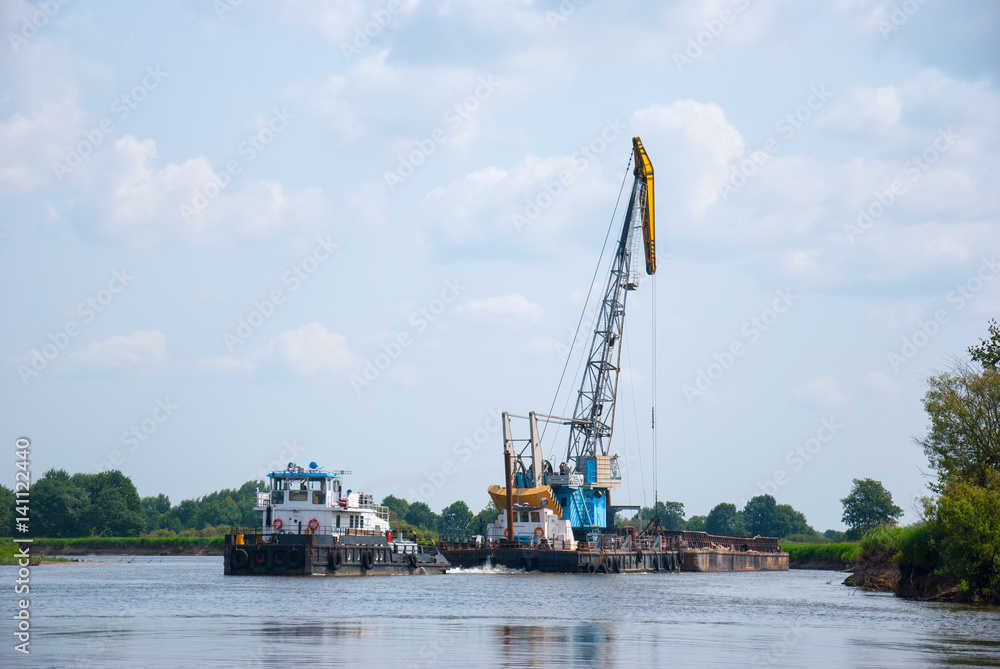 The cargo barge floats on the river