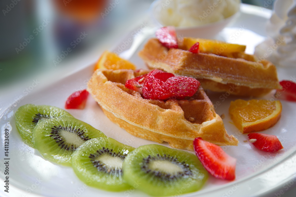 fruit waffle kiwi strawberry dessert on white dish