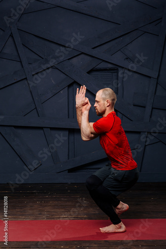 Man practicing advanced yoga against a urban background