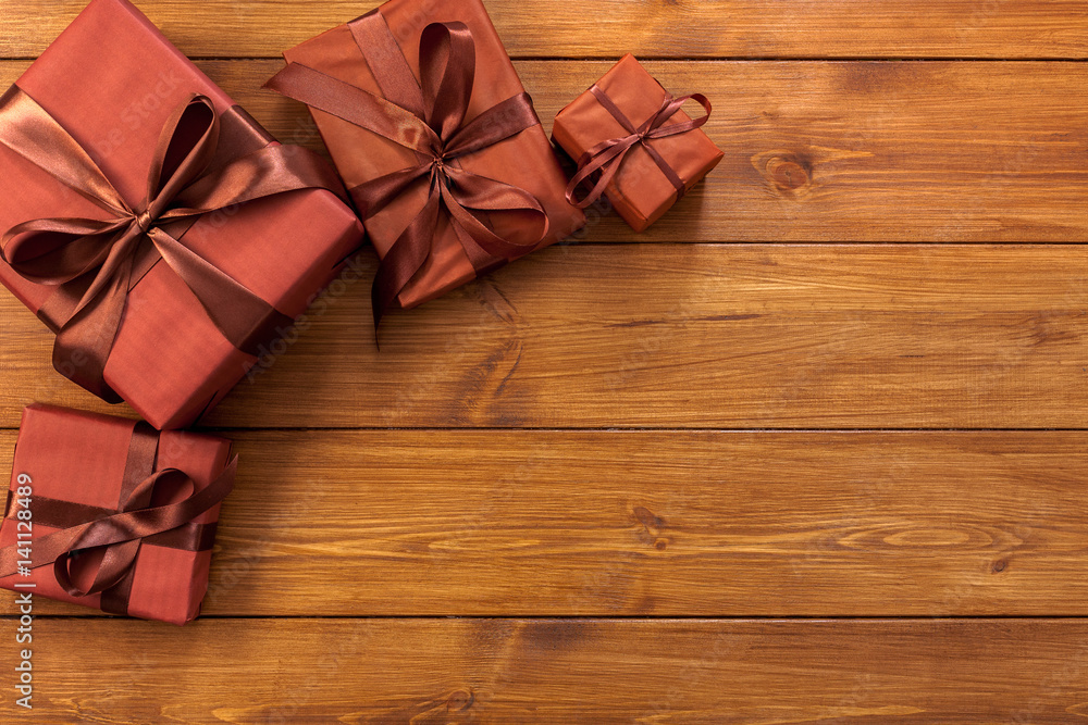 Fototapeta premium Presents in gift boxes on wood background with copy space