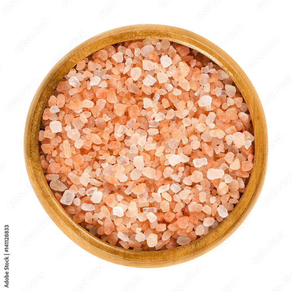 Himalayan salt in wooden bowl. Rock salt. Halite from Punjab region, Pakistan. Similar to table salt plus pink, reddish and beef colored mineral impurities. Macro photo close up from above over white. Himalayan salt in wooden bowl. Rock salt. Halite from Punjab region, Pakistan. Similar to table salt plus pink, reddish and beef colored mineral impurities. Macro photo close up from above over white.