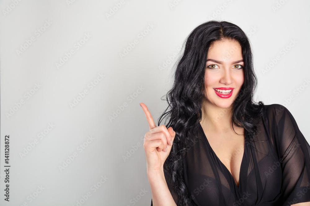 Beautiful brunette woman laughs and points with an index finger. Sale, share, gift, attention. Mock up. Beautiful brunette woman laughs and points with an index finger. Sale, share, gift, attention. Mock up.