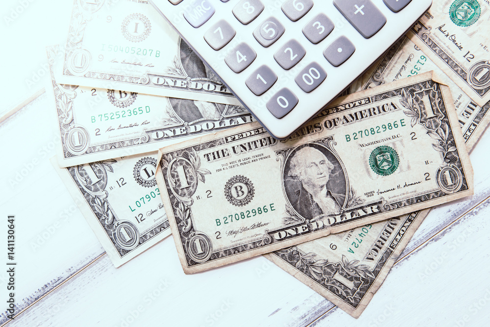 Calculator with american dollars on the wooden table background, finance concept Calculator with american dollars on the wooden table background, finance concept