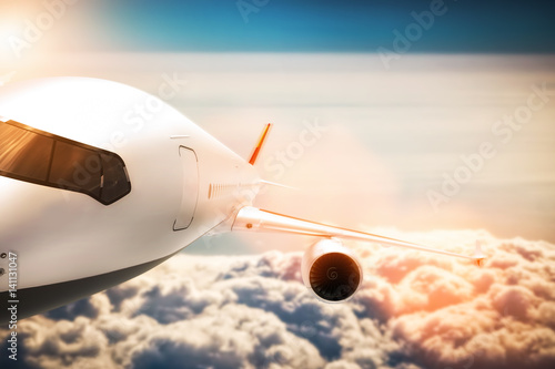 Fotografie Passenger airplane flying at sunshine, blue sky.