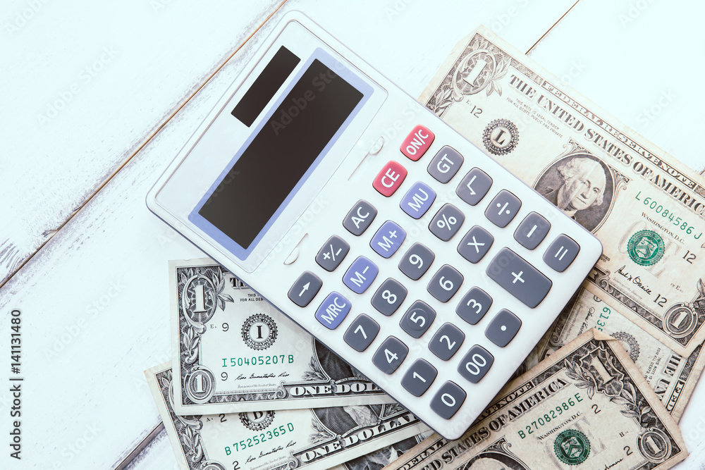 Calculator with american dollars on the wooden table background, finance concept Calculator with american dollars on the wooden table background, finance concept
