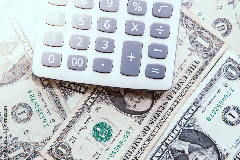 Calculator with american dollars on the wooden table background, finance concept Calculator with american dollars on the wooden table background, finance concept