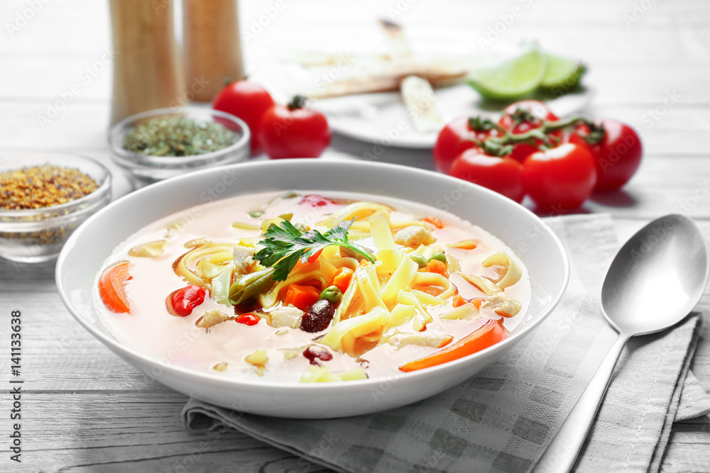 Chicken tortilla soup in plate on wooden table Chicken tortilla soup in plate on wooden table