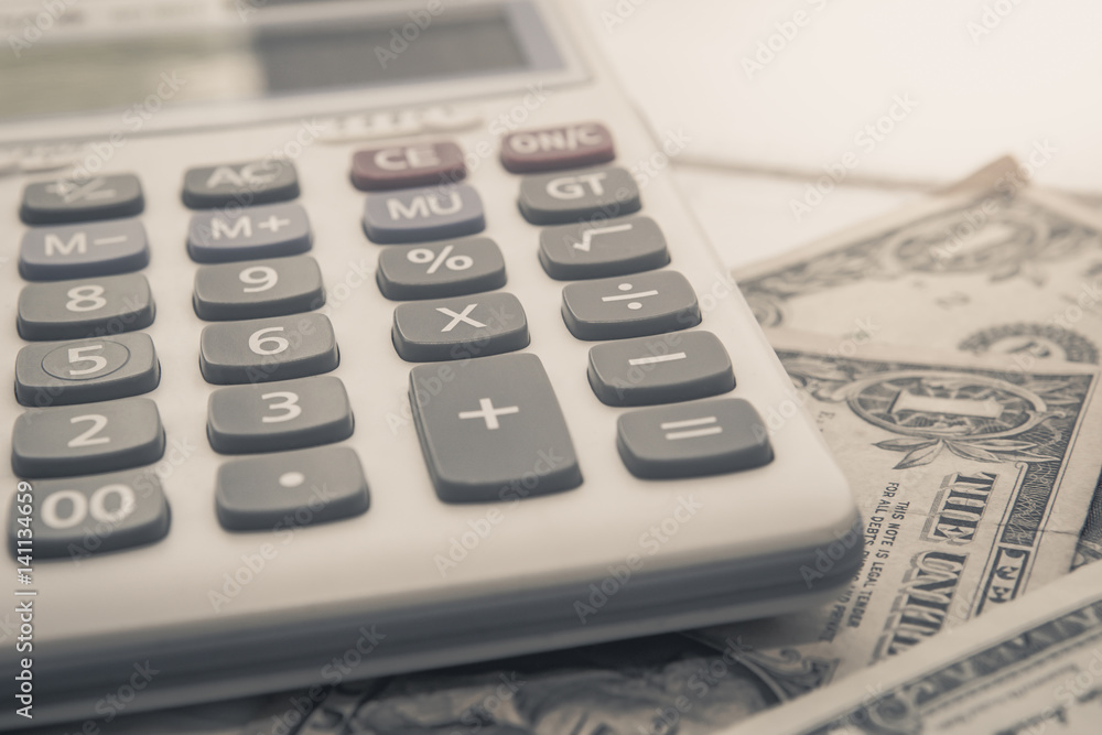 Calculator with american dollars on the wooden table background, finance concept Calculator with american dollars on the wooden table background, finance concept
