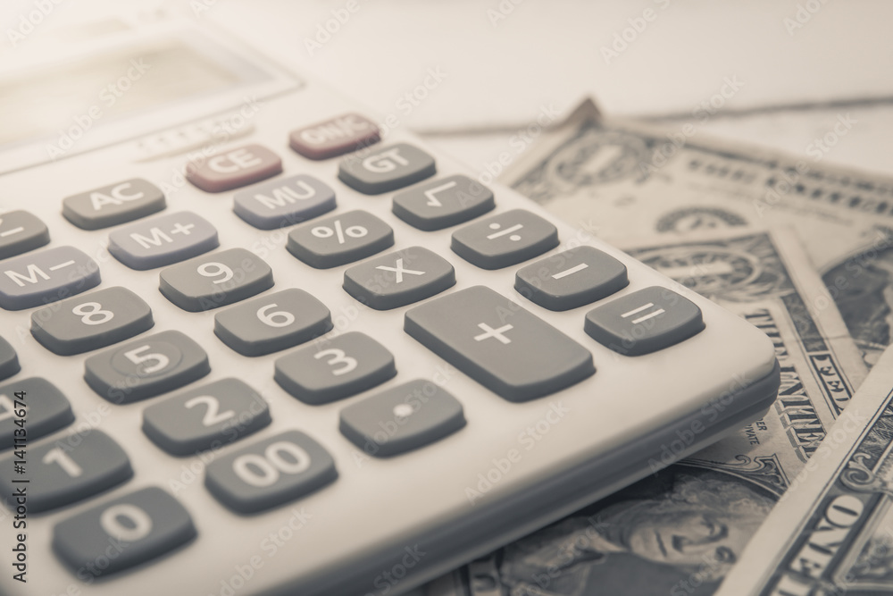 Calculator with american dollars on the wooden table background, finance concept Calculator with american dollars on the wooden table background, finance concept