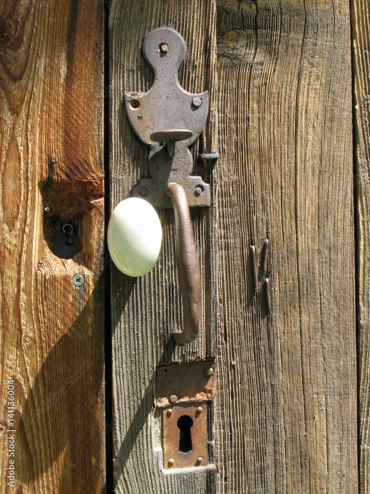 Poignée et serrure sur une vieille porte de grange Photos | Adobe Stock