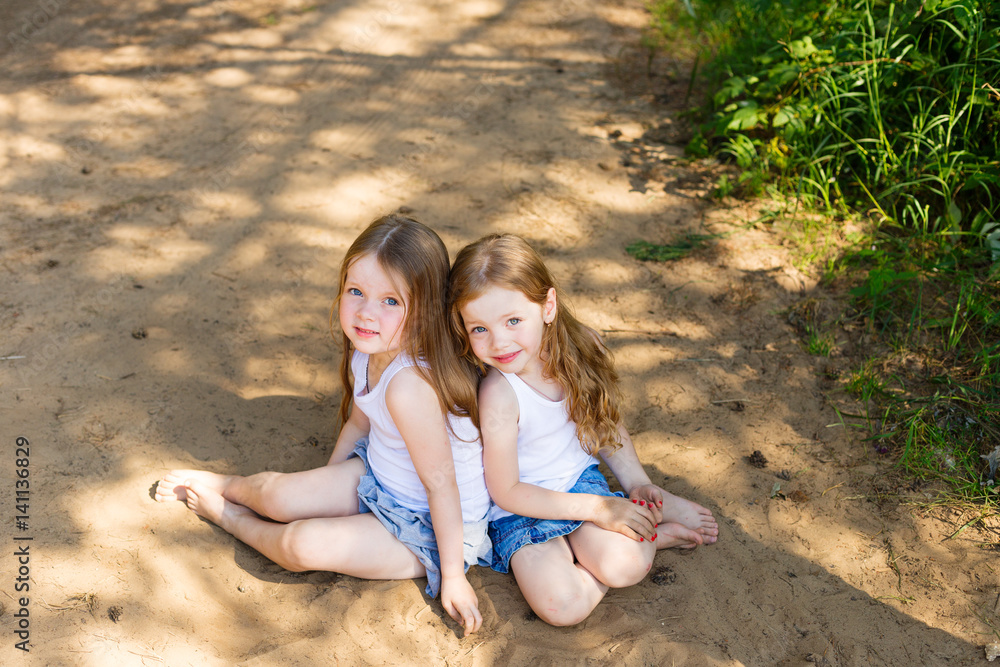 Two little girl girl friends hugging in the forest Two little girl girl friends hugging in the forest