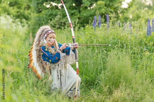 Beautiful young girl in the image of an Indian with a roucche on her head