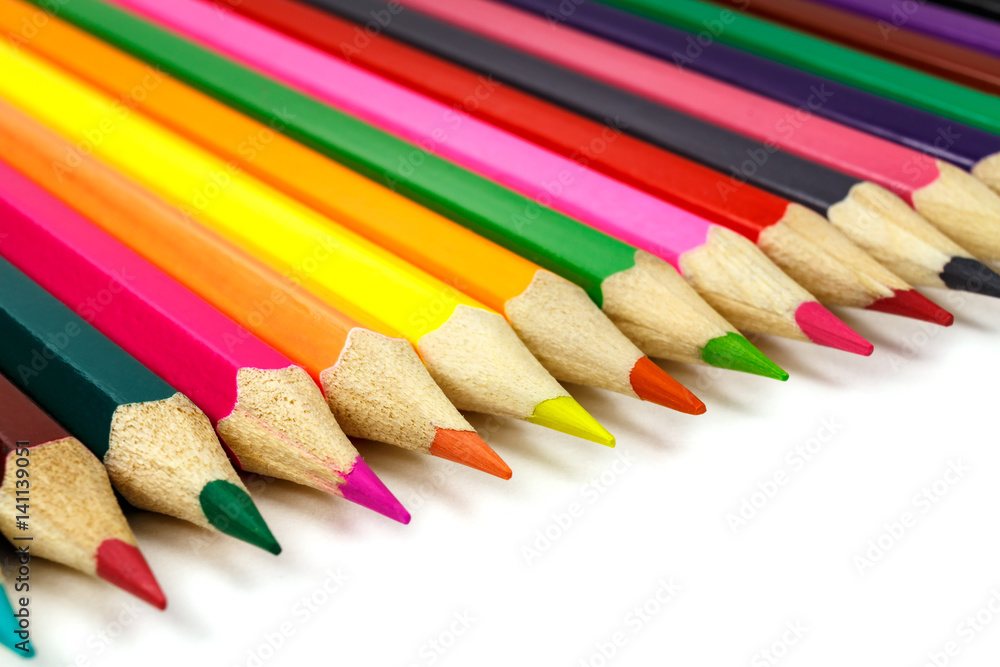 Wooden colored pencils arranged in a row on a white background Wooden colored pencils arranged in a row on a white background