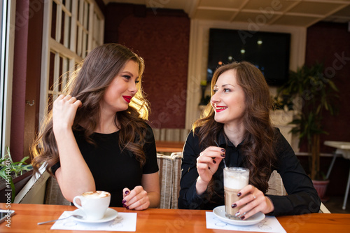 Two beautiful girls drinking coffee