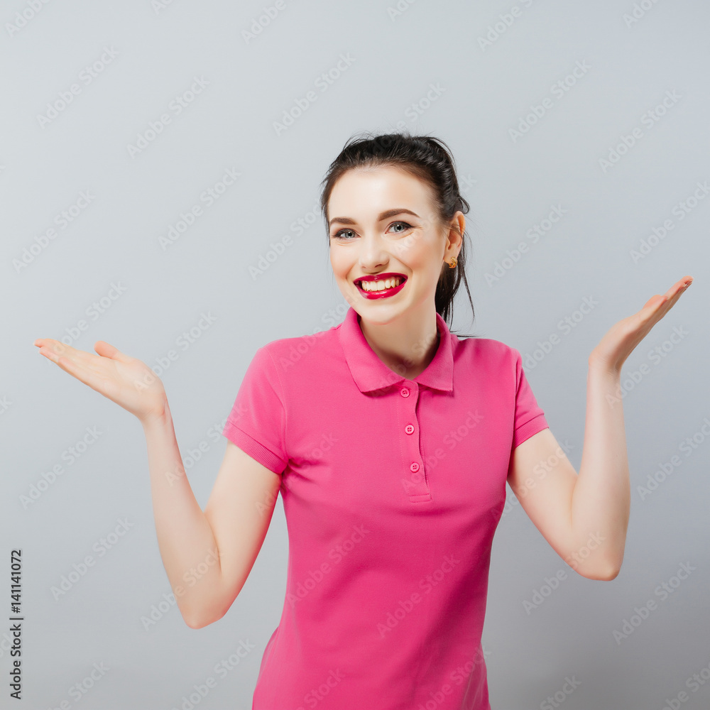 Smiling young beautiful brunette woman posing in studio wearing fashionable pink dress Smiling young beautiful brunette woman posing in studio wearing fashionable pink dress