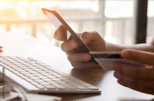 Hands holding credit card and using laptop. Online shopping