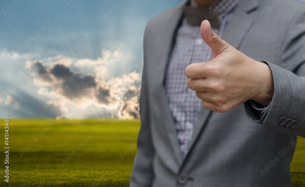 Businessman thumb up with nice green landscape background