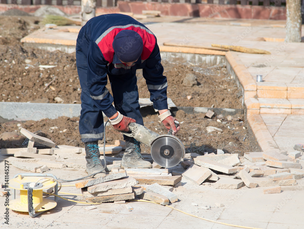 Worker cuts paving slabs
