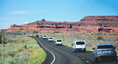 Cars on road with scenic Utah rocks in background