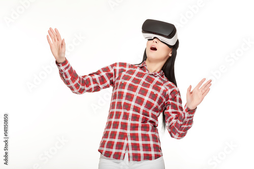 Shocked woman playing game in virtual reality and gesturing.