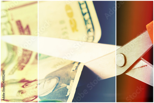 Scissors cutting American currency twenty dollar bill - Budget cuts financial crisis concept