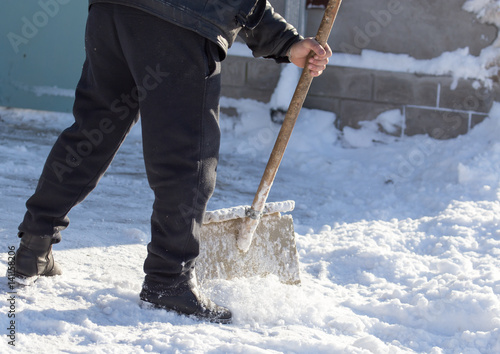 Worker cleans snow shovel