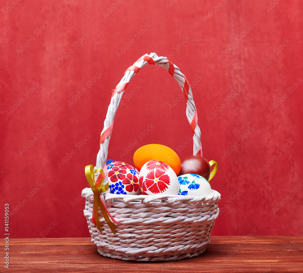 Braided Easter basket with colored eggs on a red background