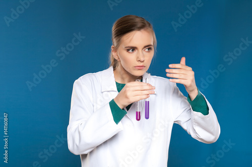 female chemist with a test tube on a blue background