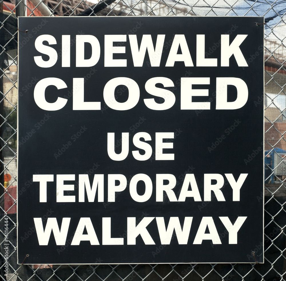 SIDEWALK CLOSED sign in black and white.