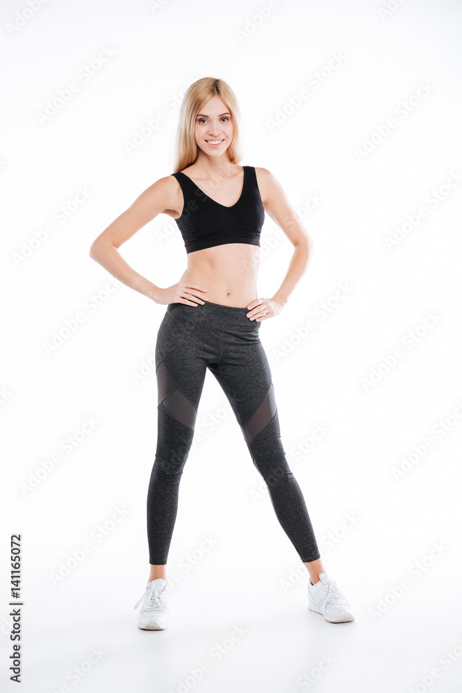 Cheerful pretty fitness woman standing and posing Cheerful pretty fitness woman standing and posing