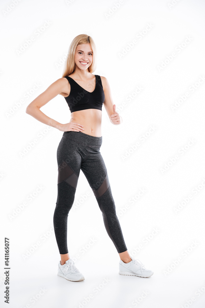 Smiling pretty fitness woman make thumbs up gesture. Smiling pretty fitness woman make thumbs up gesture.