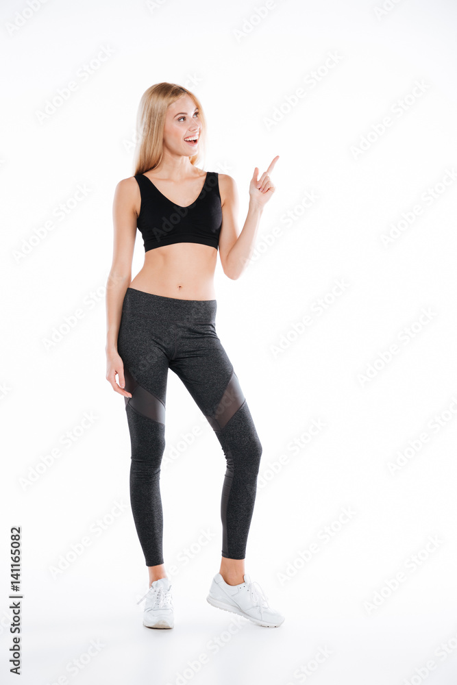 Smiling pretty fitness woman pointing to copyspace. Smiling pretty fitness woman pointing to copyspace.