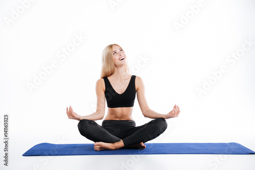 Smiling fitness woman sitting make yoga exercises