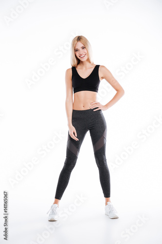 Happy beautiful fitness woman standing and posing