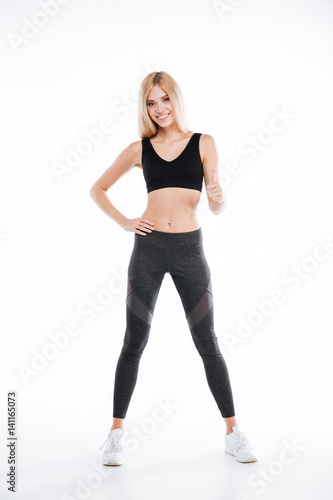 Happy pretty fitness woman make thumbs up gesture.