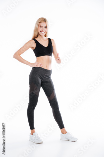 Smiling pretty fitness woman make thumbs up gesture.