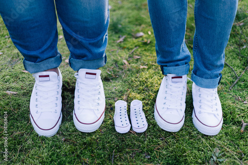 Nachwuchs erwartet - Babyschuhe neben Schuhe der Eltern © Michael
