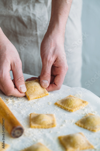 The man is cooking Ravioli with spinach and ricotta cheese