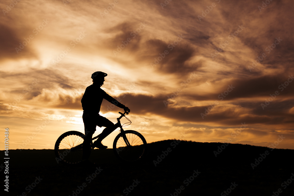 Obraz premium Silhouette of a person on a bike
