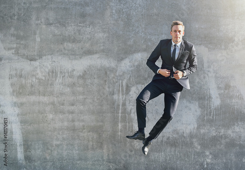 A jumping happy businessman looking at camera