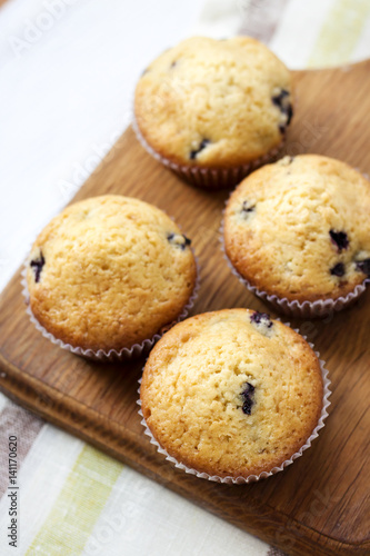 Homemade muffins with blueberries on a wooden board
