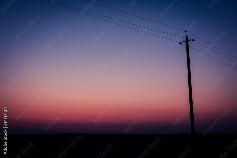Single electric power pole on at sunrise, natural envirnomental clear energy background