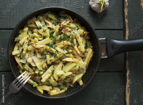 Potatoes fried in a frying pan. Table setting in country style