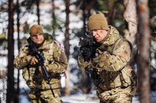 team of special forces weapons in cold forest. Winter warfare and military concept