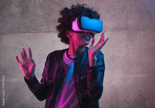 A girl playing with VR headset photo